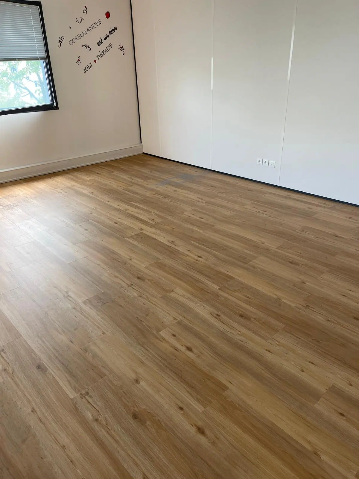 Sol stratifié chêne clair posé dans une chambre contemporaine