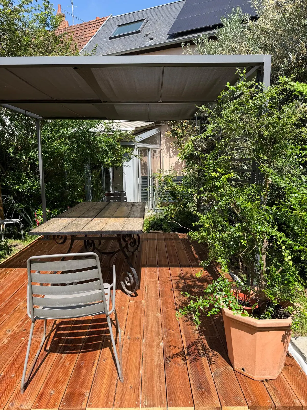 Terrasse en pin dans un jardin avec pergola et coin repas près d'Orléans