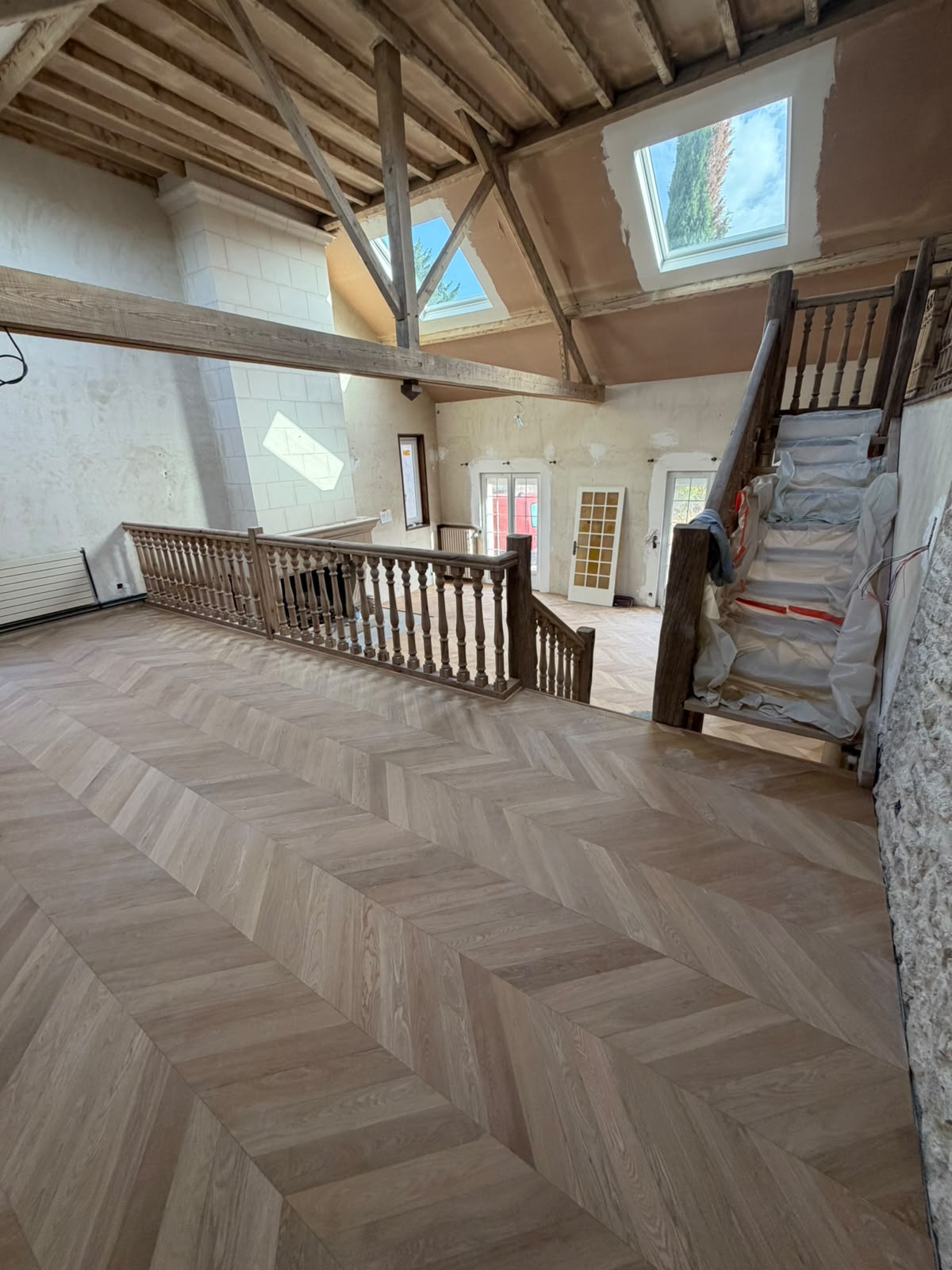 Parquet contrecollé pointe de Hongrie collé sur le palier, dans le prolongement du salon (NATURABOIS, artisan à Orléans)