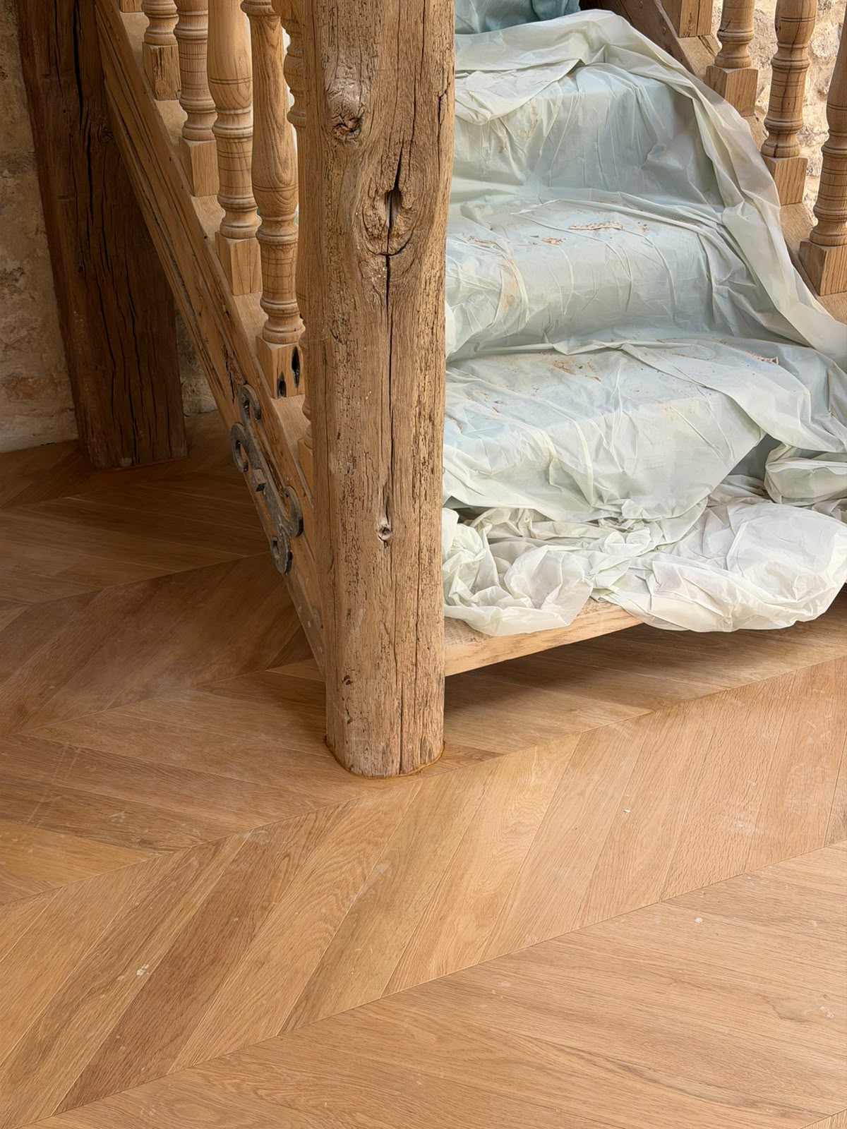 Découpe sur mesure du parquet pointe de Hongrie au pied d'un poteau de charpente ancien (NATURABOIS, artisan à Orléans)