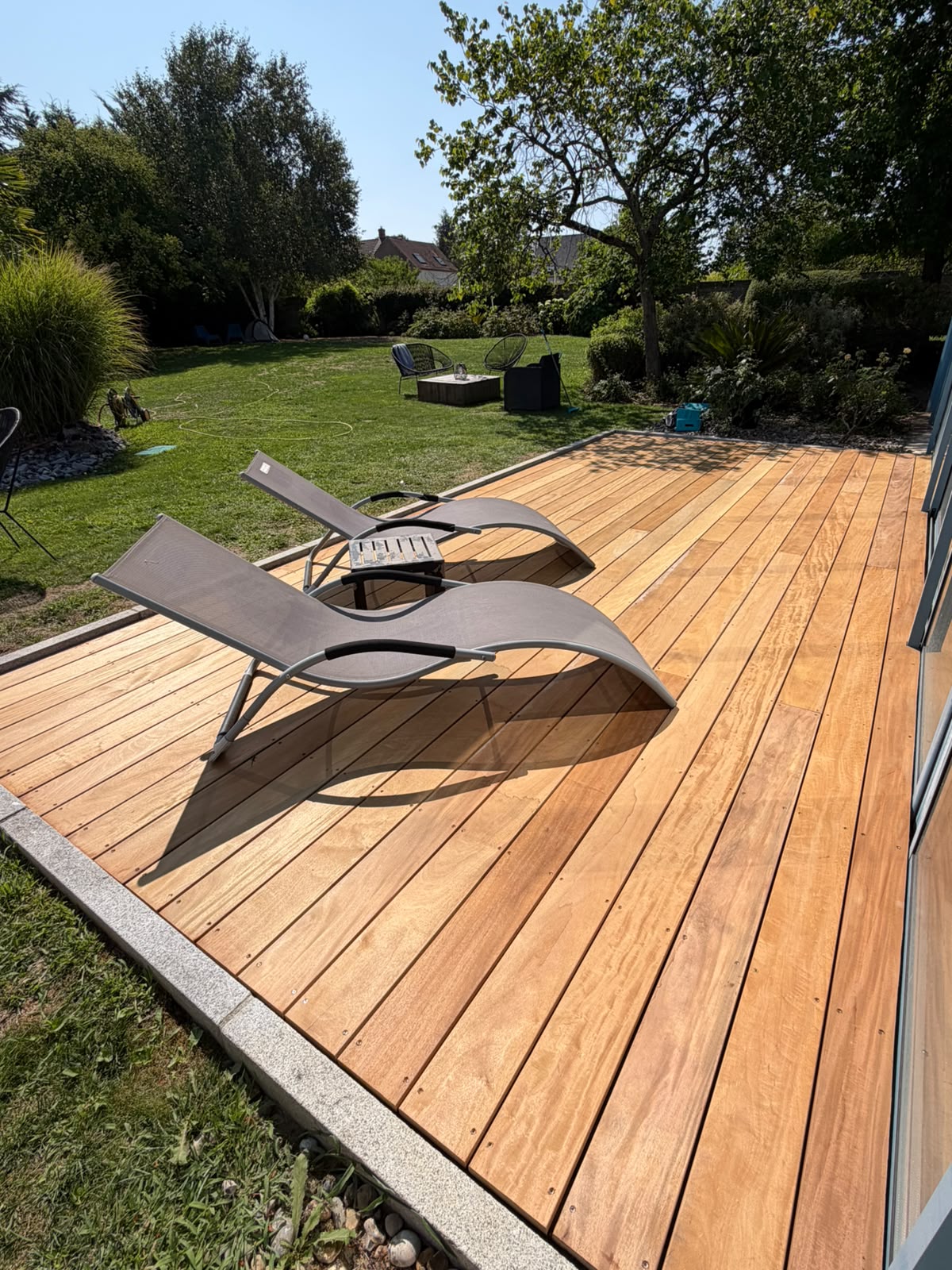 Terrasse en bois exotique Garapa ouverte sur le jardin, aménagée en espace détente (NATURABOIS, artisan à Orléans)